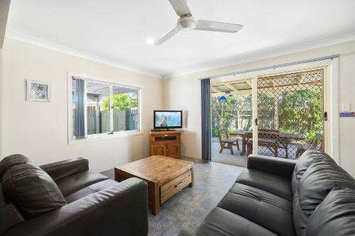 a living room with a couch and a table at PJ's Cottage - Bring your own linen. in South West Rocks