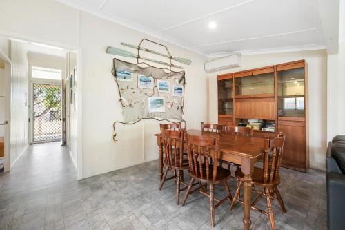 a dining room with a wooden table and chairs at PJ's Cottage - Bring your own linen. in South West Rocks