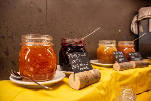 a table with two jars of honey and some food at DolceVita Ambiez B&B in San Lorenzo in Banale