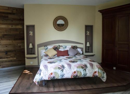 um quarto com uma cama grande e um edredão colorido em L'AUGLANAS em Tauriac-de-Naucelle