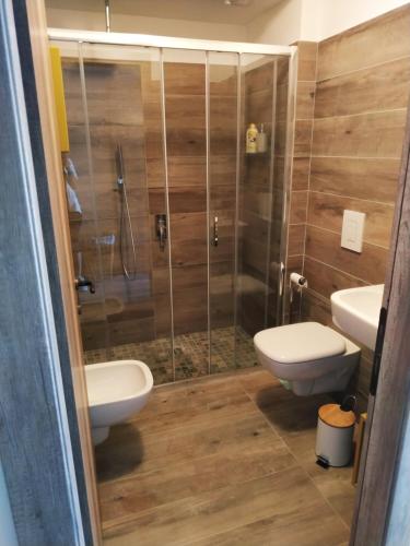 a bathroom with two toilets and a shower at Il Giardino di Marzo Guest House in Monti di Licciana Nardi