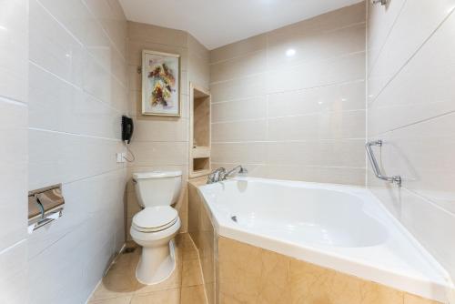 a white bathroom with a toilet and a bath tub at Yun-Zen Century Hotel in Shijiazhuang