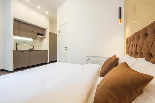 a bedroom with a large white bed with brown pillows at Cheap Apartments in Kyiv