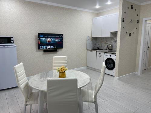 a kitchen and dining room with a table and chairs at АУЕЗОВА 189б ЖК Салтанат Центр Евродвушка с 2 х спальной кроватью и двумя диванами in Kokshetau