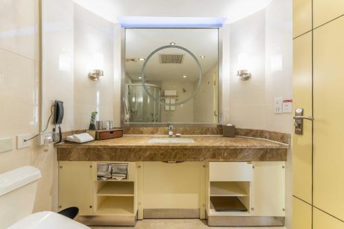 a bathroom with a sink and a mirror at Yun-Zen Century Hotel in Shijiazhuang