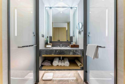 a bathroom with a sink and a mirror at Yun-Zen Century Hotel in Shijiazhuang