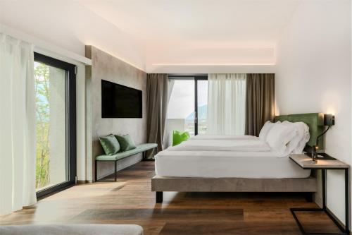 a bedroom with a large white bed and large windows at ARCOLIVE Agrisuite in Arco