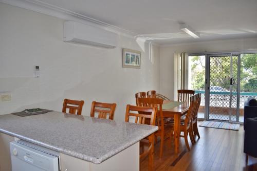 a kitchen and dining room with a table and chairs at Mariner 16 Flat 1 South West Rocks in South West Rocks