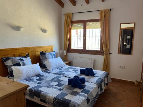 een slaapkamer met twee bedden met blauwe bogen erop bij El Valle Verde in Monte Pego