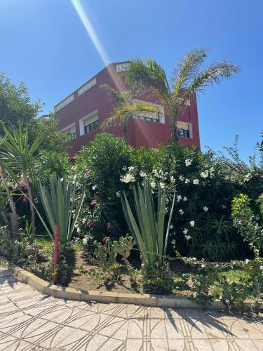 a building with a bunch of plants in front of it at Mehdia Ville in Plage de Mehdia