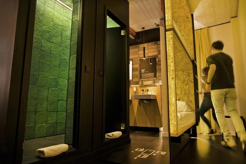 a man is standing in a bathroom with a sink at Bastardo Hostel in Madrid