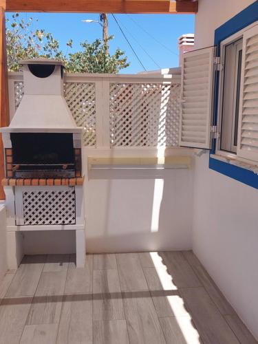 a patio with a grill on a white fence at Casa Azul do Cerro in Campeiros