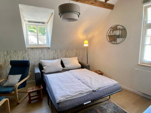 1 dormitorio con 1 cama y 1 silla azul en Gästehaus Rheinromantik, en Bacharach
