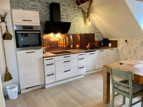 a kitchen with white cabinets and a wooden table at Gästehaus Rheinromantik in Bacharach