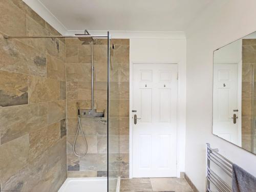 a bathroom with a shower with a glass door at Coastal - Wittering in West Wittering
