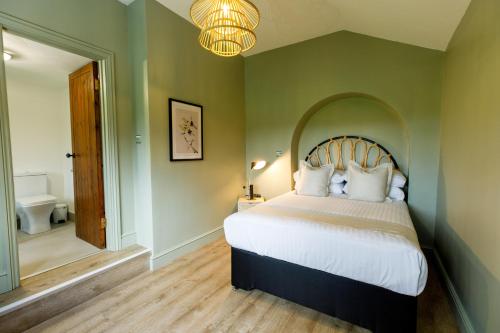 a bedroom with a large bed and a chandelier at The Granary in Swansea