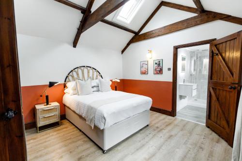 a bedroom with a white bed and a bathroom at The Granary in Swansea