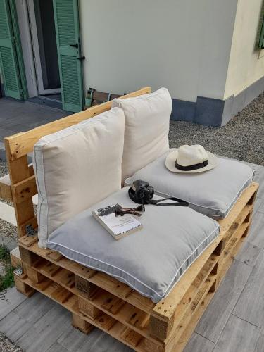 two pillows and a hat sitting on a wooden bench at Il Giardino di Marzo Guest House in Monti di Licciana Nardi