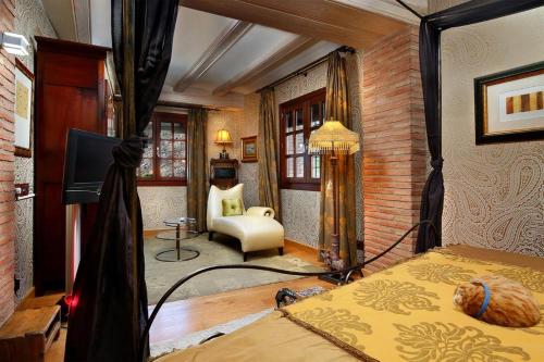 ein Schlafzimmer mit einem Bett und einem Stuhl in einem Zimmer in der Unterkunft Casa Rural La Parra de Maribel in Alquézar