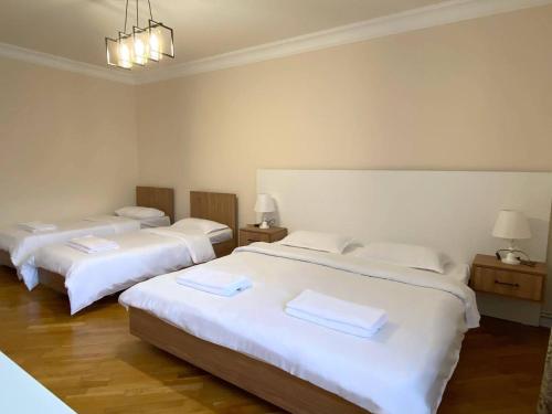 Habitación con 2 camas con sábanas blancas y 2 lámparas en ECO PARK RESORT, en Ijevan