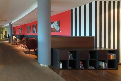 a lobby with a book shelf and a staircase at Ramada by Wyndham Dresden in Dresden
