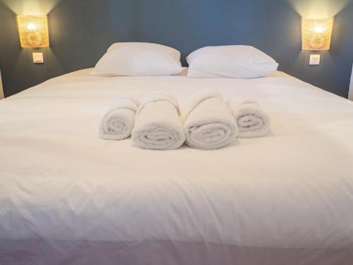 een wit bed met drie handdoeken erop bij Le Cocoon - Appartement cocooning à Orange in Orange