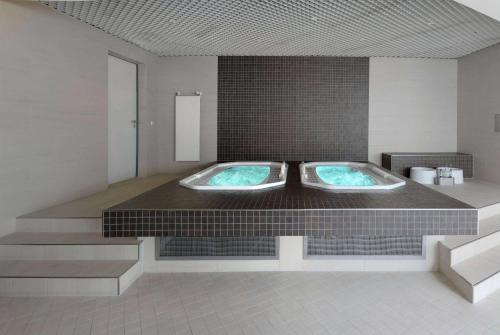 a bathroom with two jacuzzi tubs in a room at Ramada by Wyndham Dresden in Dresden