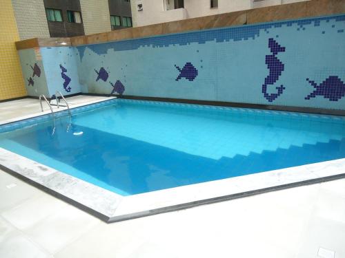 a large swimming pool with a blue tile wall at Flat em Boa Viagem in Recife