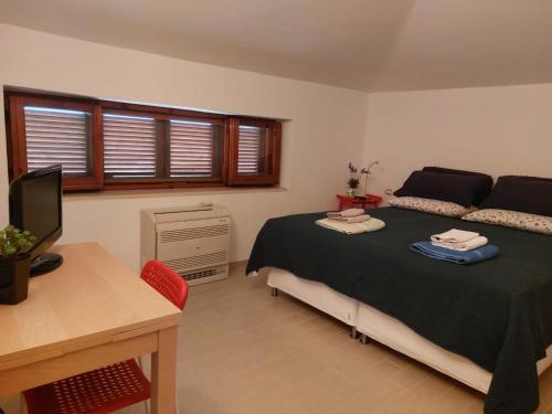 a bedroom with a bed and a desk with a computer at La Quercia in Altavilla Silentina