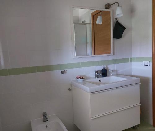 a white bathroom with a sink and a mirror at La Quercia in Altavilla Silentina