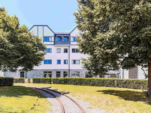 a building with a train track in front of it at Mercure Han-sur-Lesse in Han-sur-Lesse