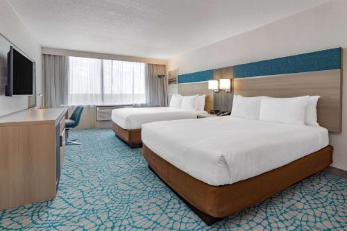 a hotel room with two beds and a television at Wyndham Orlando Resort & Conference Center, Celebration Area in Orlando
