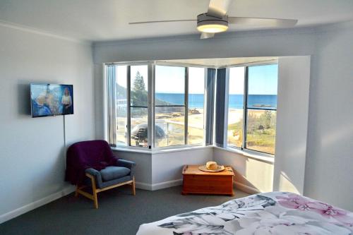 Un dormitorio con una cama y una ventana con vista al mar. en Ocean Shores Apartment 17 - Bring you own linen., en South West Rocks