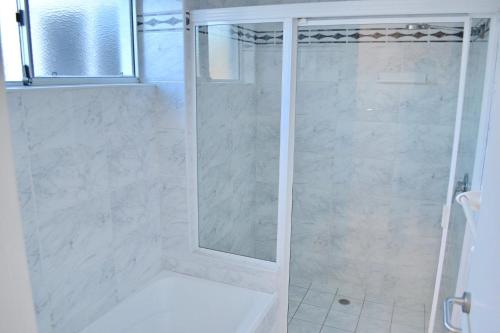 una ducha con puerta de cristal en un baño en Ocean Shores Apartment 17 - Bring you own linen., en South West Rocks