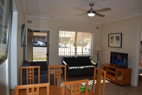 ein Wohnzimmer mit einem Sofa und einem Tisch in der Unterkunft Clarkes Flat 1 in South West Rocks