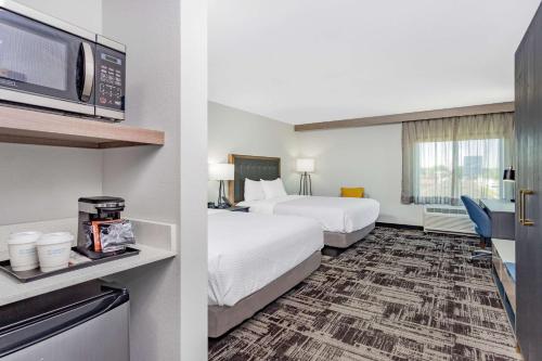 um quarto de hotel com duas camas e uma televisão em La Quinta Inn & Suites by Wyndham South Bend near Notre Dame em South Bend
