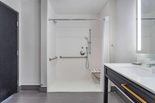 a white bathroom with a shower and a sink at La Quinta Inn & Suites by Wyndham South Bend near Notre Dame in South Bend