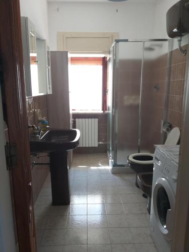 La salle de bains est pourvue d'un lavabo, d'une douche et de toilettes. dans l'établissement Casa Trullo Sole, à Cisternino