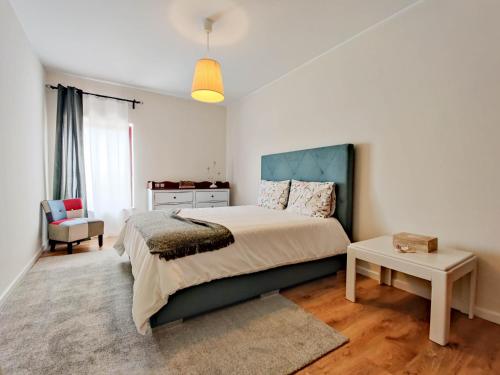 - une chambre avec un lit, une table et une chaise dans l'établissement Da Silva House - Ap in Afife with Balcony & SeaView, à Viana do Castelo
