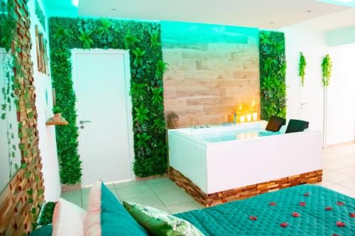 a wellness room with a tub with plants on the wall at Monti-love in Montivilliers