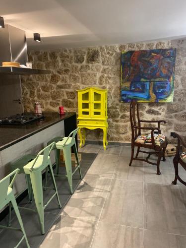 a kitchen with green chairs and a yellow table at Casa da Avó Maria in Monsanto