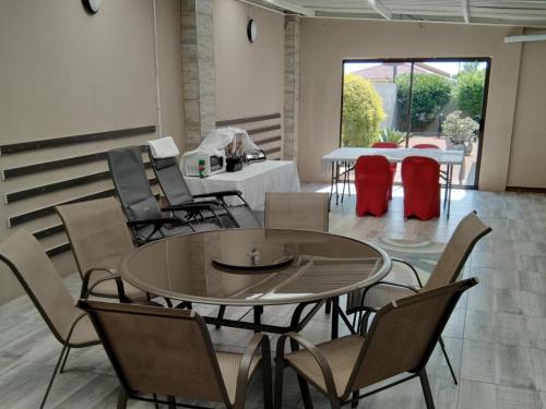 uma sala de jantar com mesa e cadeiras em Bayside guesthouse em East London