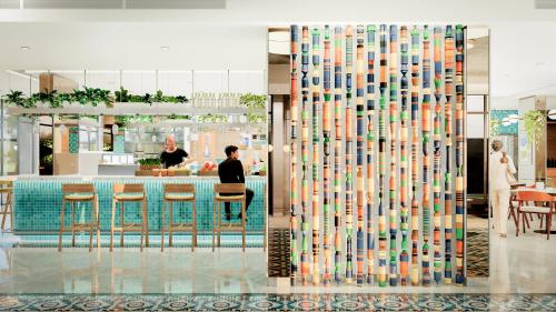 a lobby with a glass wall with a bar at Zone By The Park Gopalpur in Gopālpur