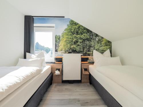 2 Betten in einem Zimmer mit Fenster in der Unterkunft Gasthof Wisonbrona in Sankt Vith