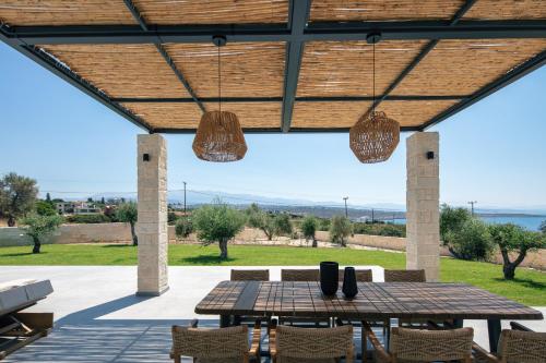un patio con mesa, sillas y luces en Ikritis Villas, en Chorafakia