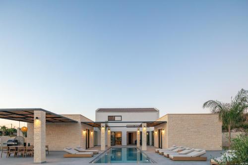 an exterior view of a house with a swimming pool at Ikritis Villas in Chorafakia