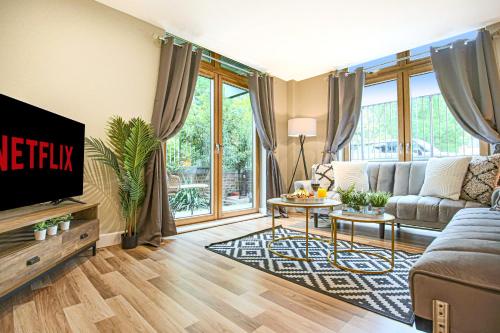 a living room with a couch and a tv at Campbell Park Apartment - City Centre - Free Parking, Balcony, Super-Fast Wifi and Smart TV with Netflix by Yoko Property in Milton Keynes