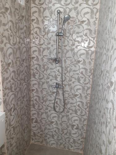 a shower in a bathroom with a patterned wall at Luxuries Beta in Saturn