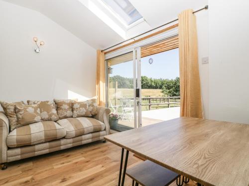 a living room with a couch and a table at Steel Works Farm in Ross on Wye