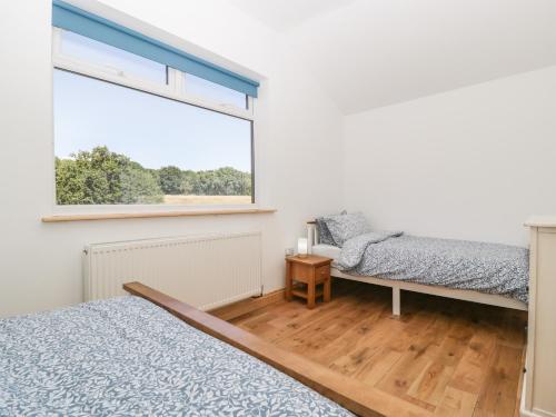 a bedroom with two beds and a window at Steel Works Farm in Ross on Wye